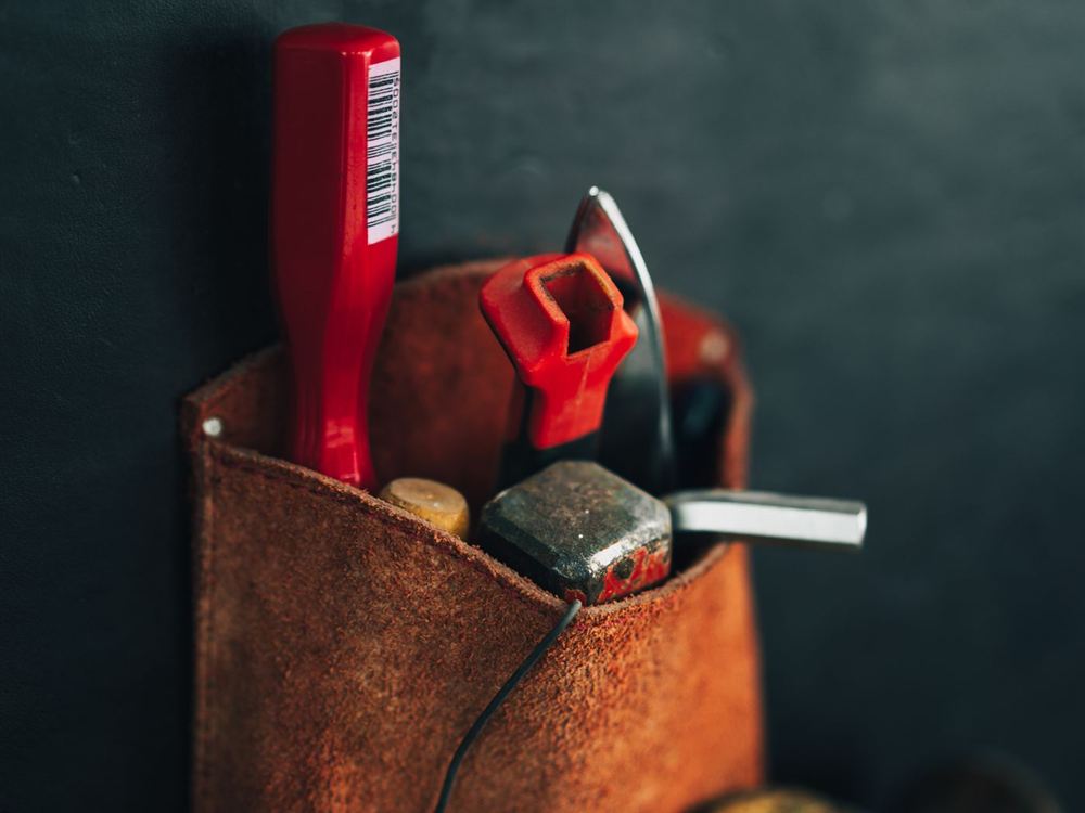 Leather tool pouch holding the hand tools used on a garage door service call