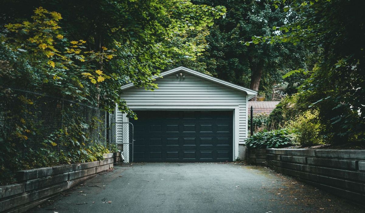 Detached laneway garage with a dark door at the back of a Toronto lot