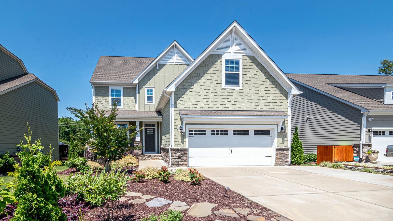 Suburban home with a white double garage door on a clear day