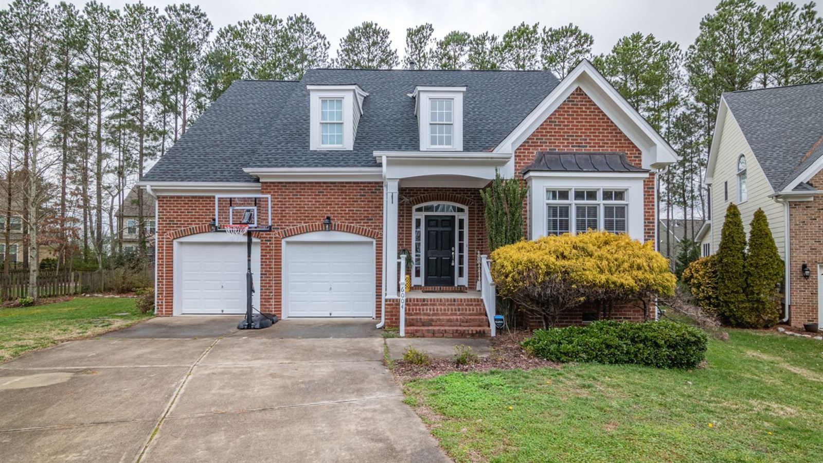 Brick home with two white garage doors on a quiet Durham Region street