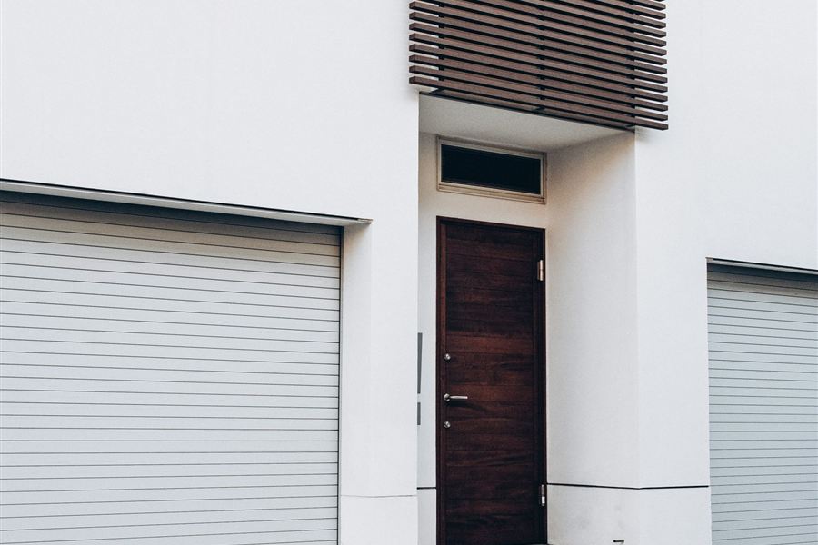Contemporary garage doors on a white rendered house