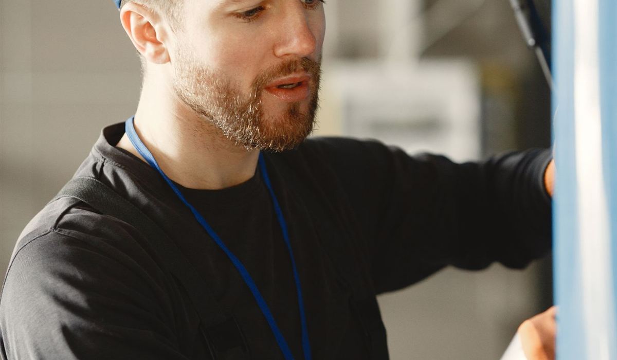 Technician in a work cap adjusting equipment